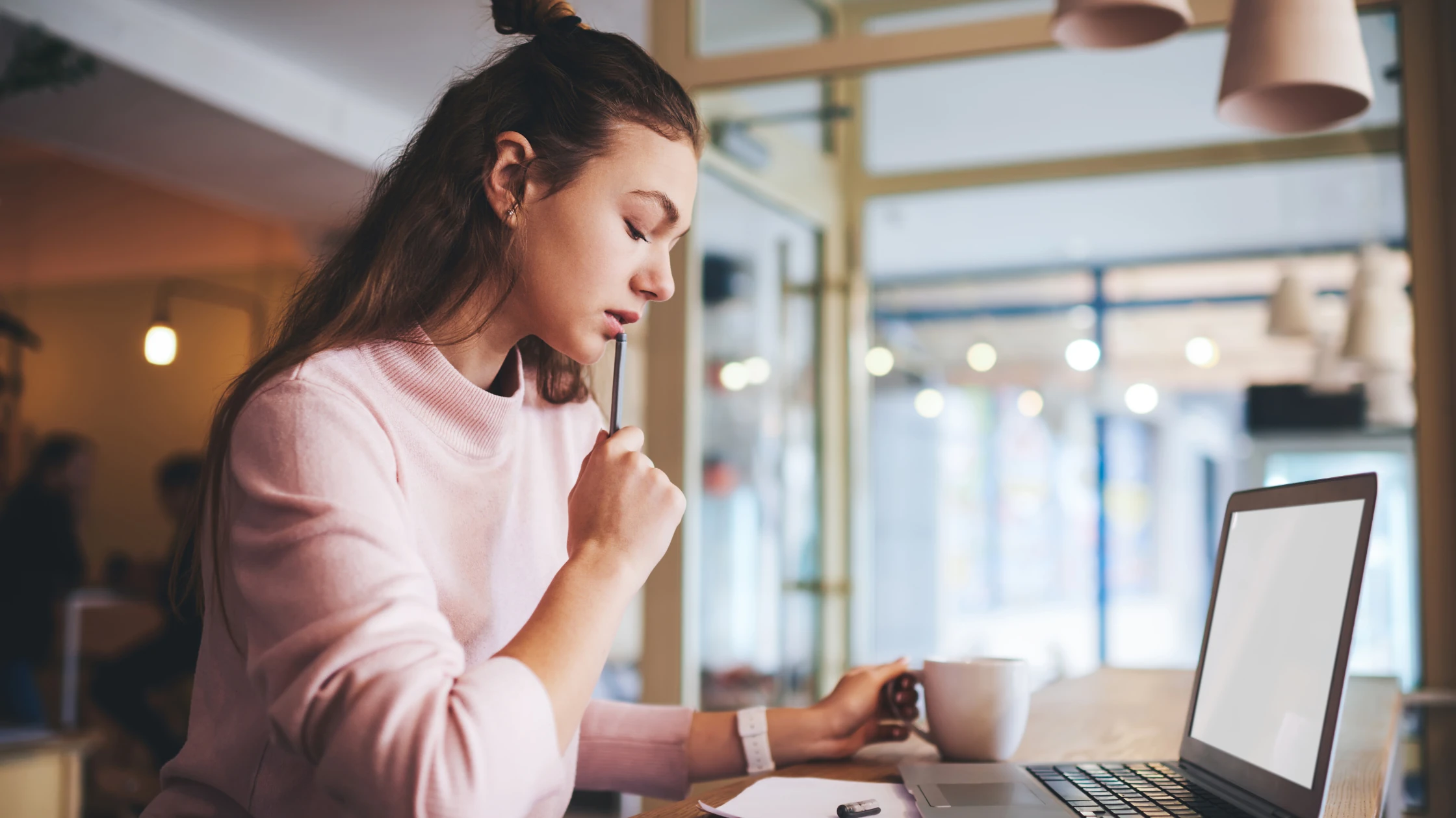 A medical school student studying for her Step 1 exam in a library in front of a laptop.